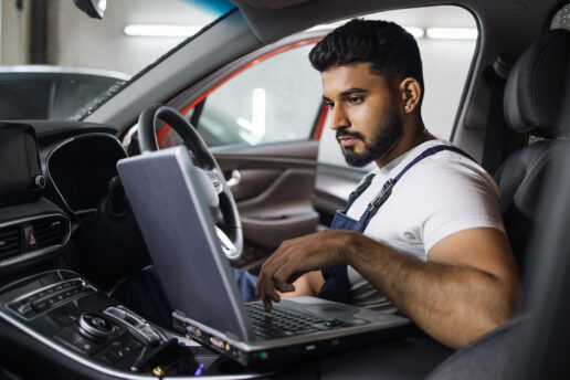 ADAS Calibration Technician performing ADAS calibration inside car using diagnostic laptop – Nottingham vehicle sensor and camera calibration service.