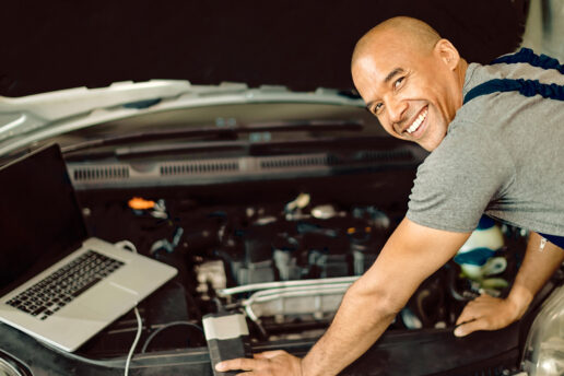 Auto Electrician at Nottingham Auto Recovery smiling over a car after remapping it.