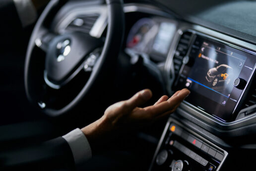 Parking Sensors & Reverse Cameras Driver interacting with a car’s reverse-camera display and parking sensor interface on the central dashboard.